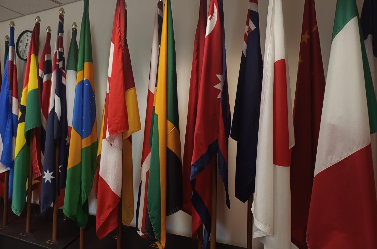 The conference room at International Student Services at SUNY Brockport features flags from various countries, representing the diverse nationalities that have been part of the university community. 